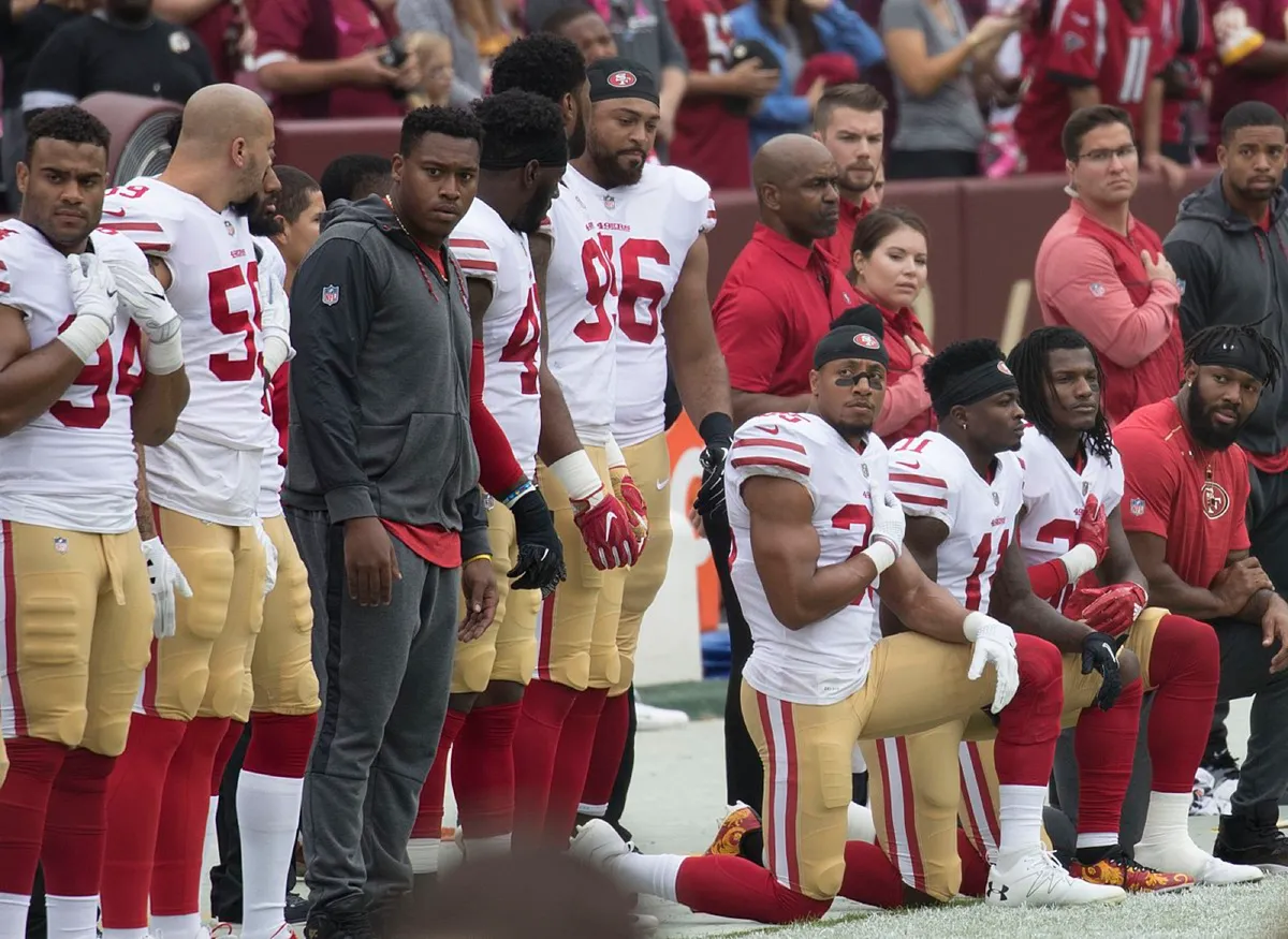 Knielende American football-spelers tijdens het volkslied